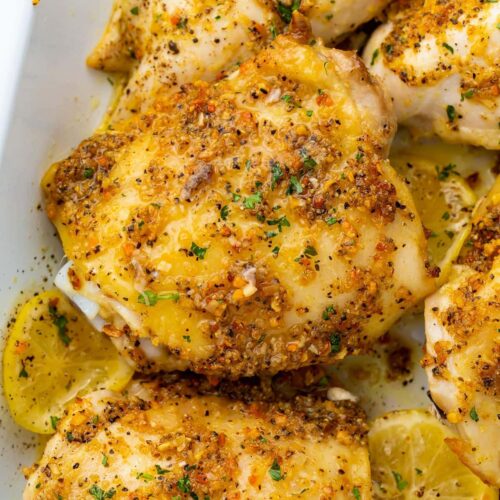 Lemon pepper chicken thighs in a white baking dish