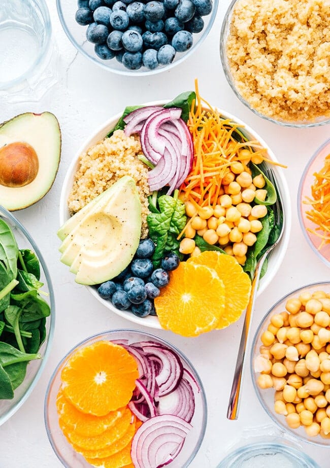 Vibrant Buddha bowl with red onion, chickpeas, grains, avocado, and blueberries