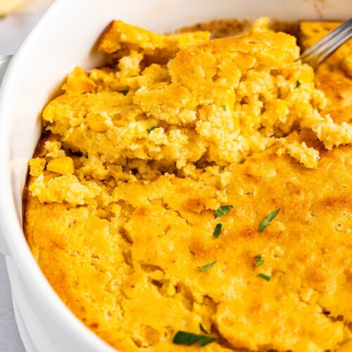 An oval casserole dish holding cornbread casserole.