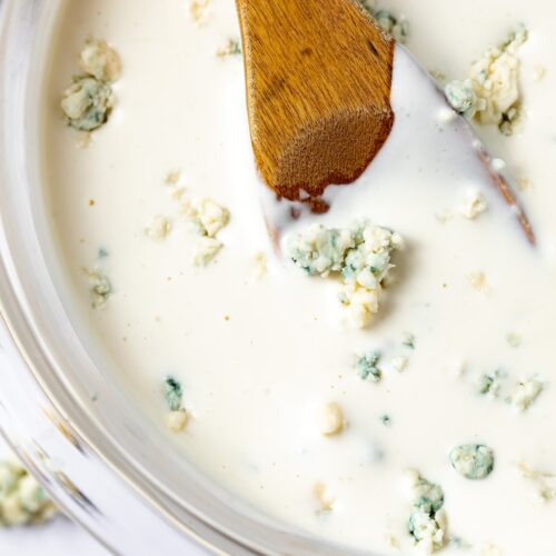 Roquefort dressing in a bowl with a wooden spoon.