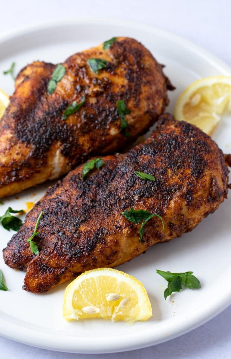 Blackened chicken on a white plate with lemon wedge garnish - easy chicken recipes for dinners with few ingredients