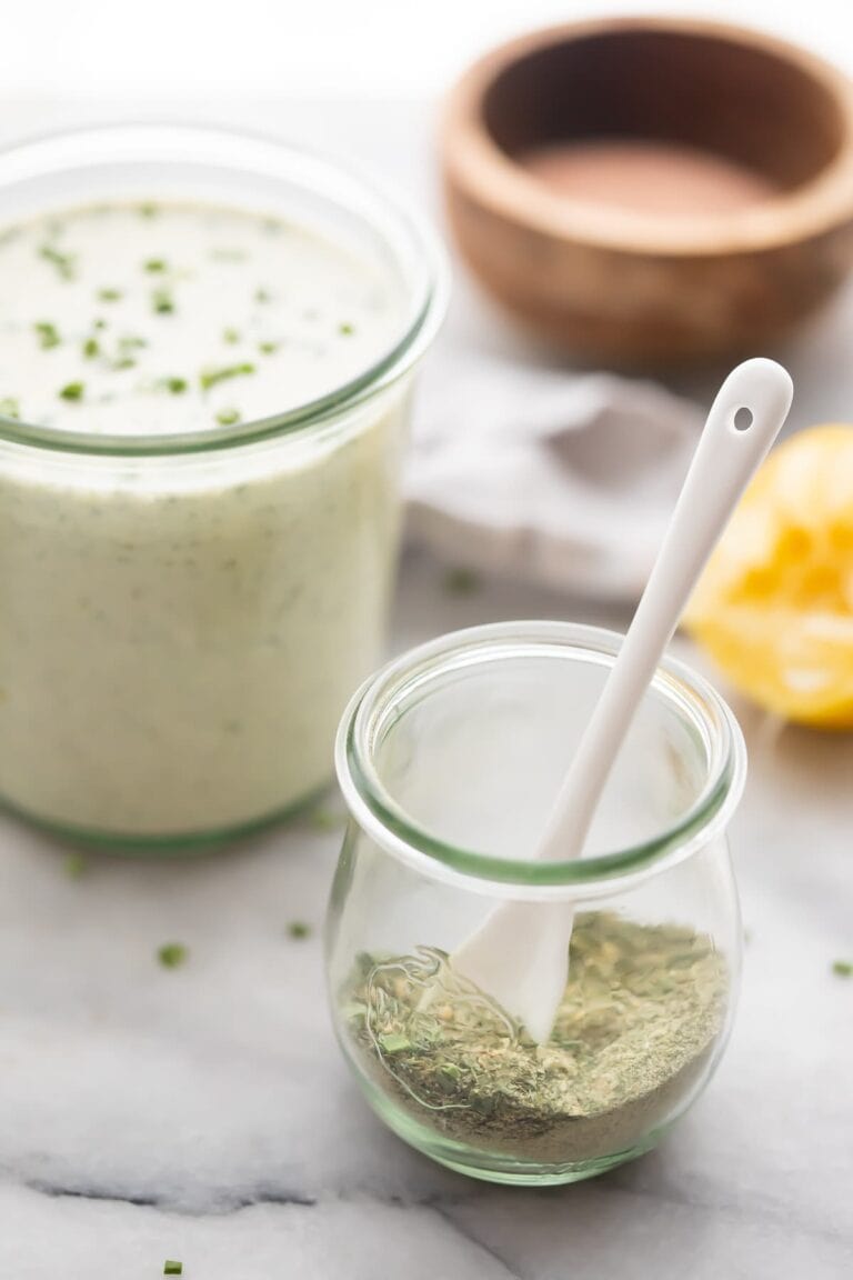 Ranch dressing mix in a glass jar next to a jar of ranch dressing