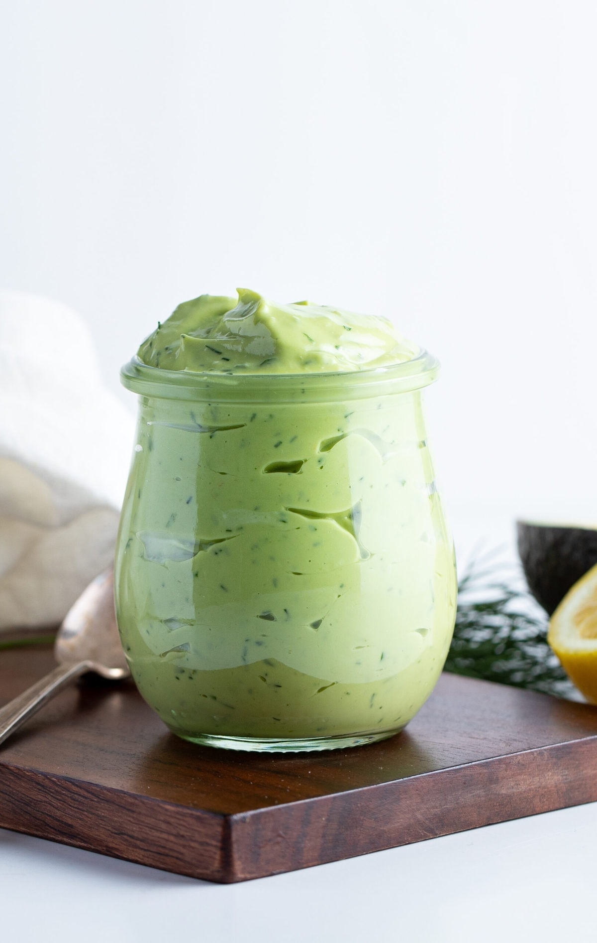 Avocado ranch dressing in a jar on a wooden board