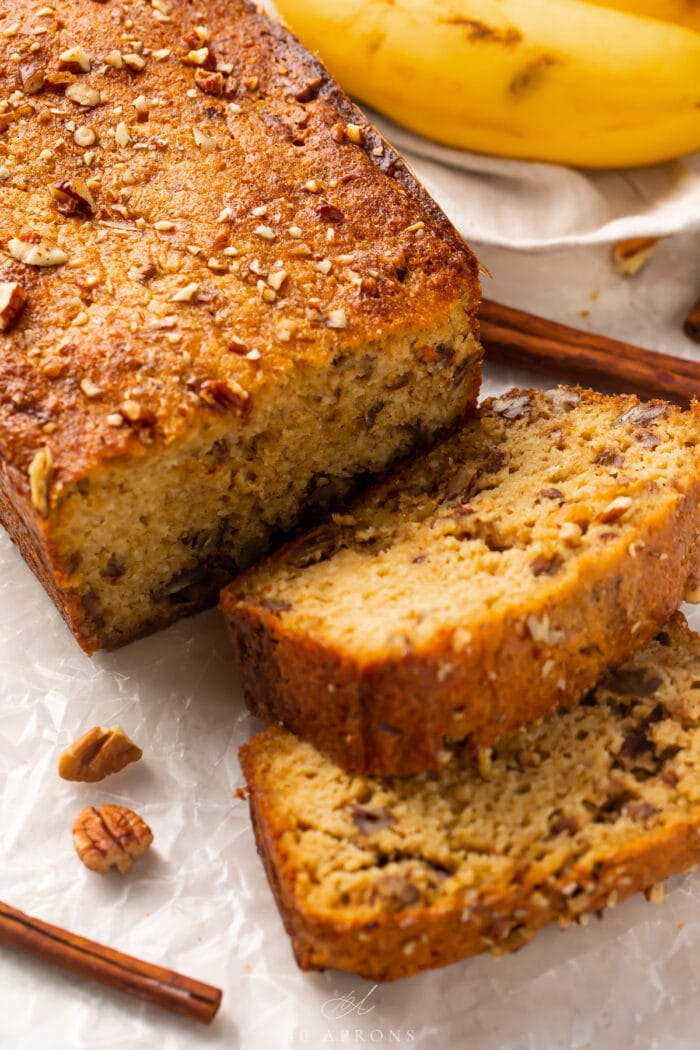 A loaf of keto banana bread with 2 pieces sliced off the end, laying one on top of the other