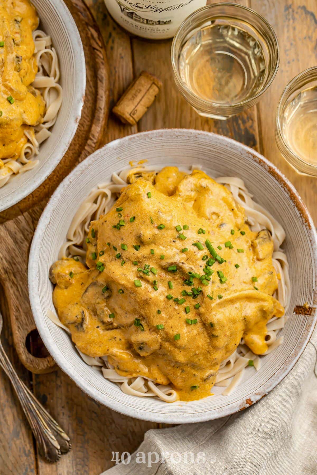 A large bowl holding angel hair pasta topped with a Crockpot-cooked chicken breast and a rich sauce.