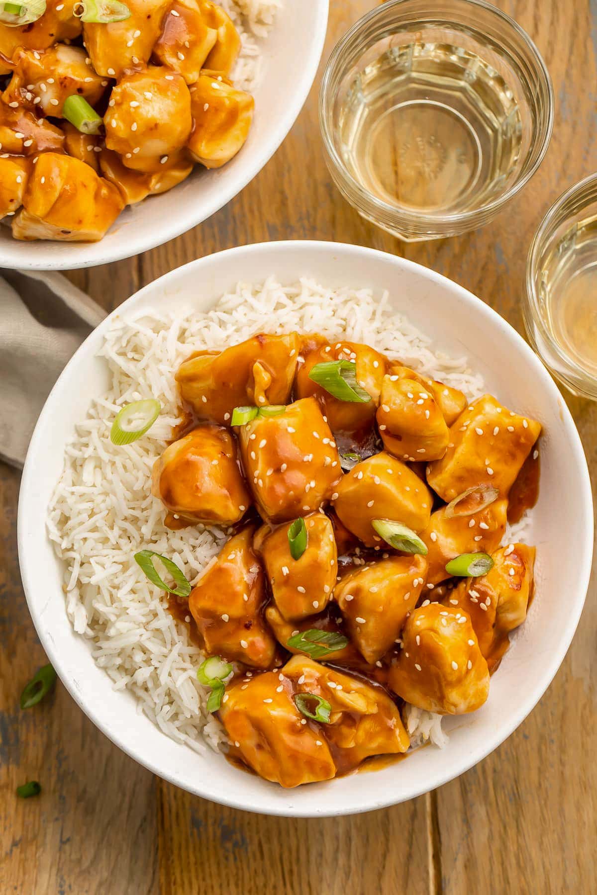 Two bowls holding white rice and cubed chicken in honey garlic sauce and cooked in the Instant Pot.