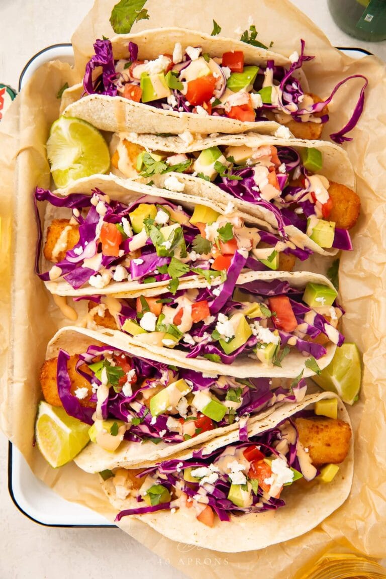 Overhead view of 6 fish stick tacos on a baking sheet