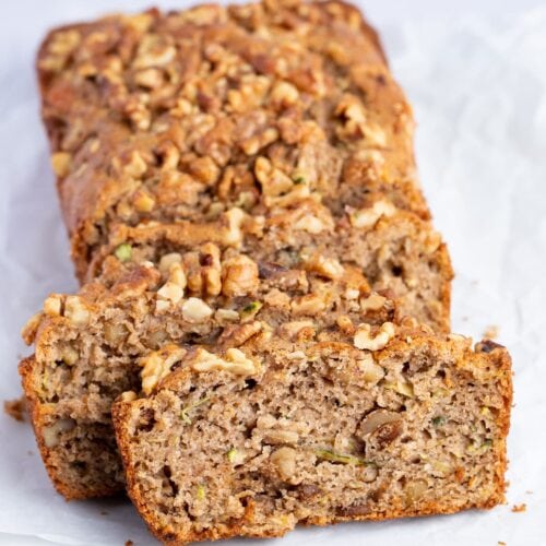 Slices of gluten free zucchini bread angled against each other on a white surface