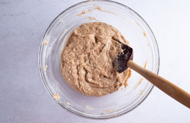 Gluten free zucchini bread batter in large glass bowl with silicone spatula