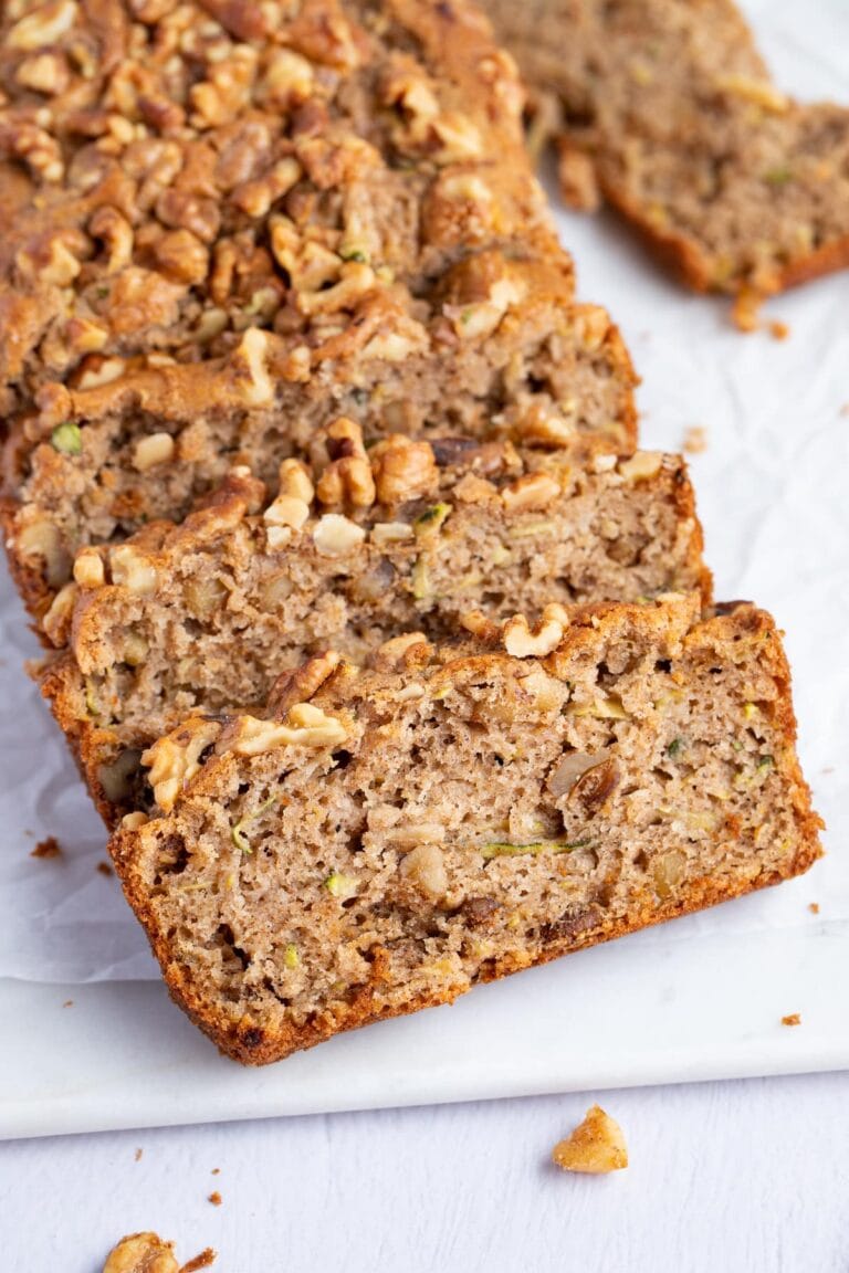 Slices of gluten free zucchini bread angled against each other on a white surface