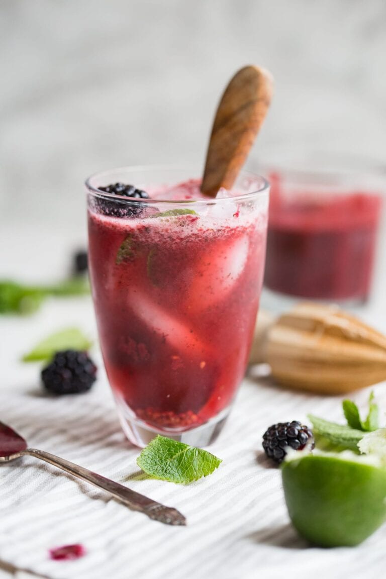 Paleo blackberry mint cocktail in a glass with a muddler