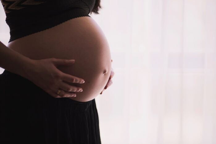 Pregnant woman with hands on belly - natural epidural birth