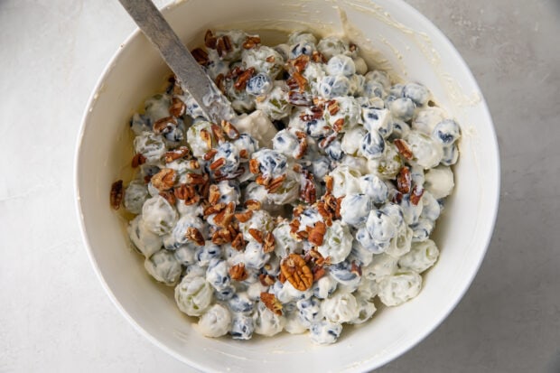 Grape salad with chopped pecans in large white bowl