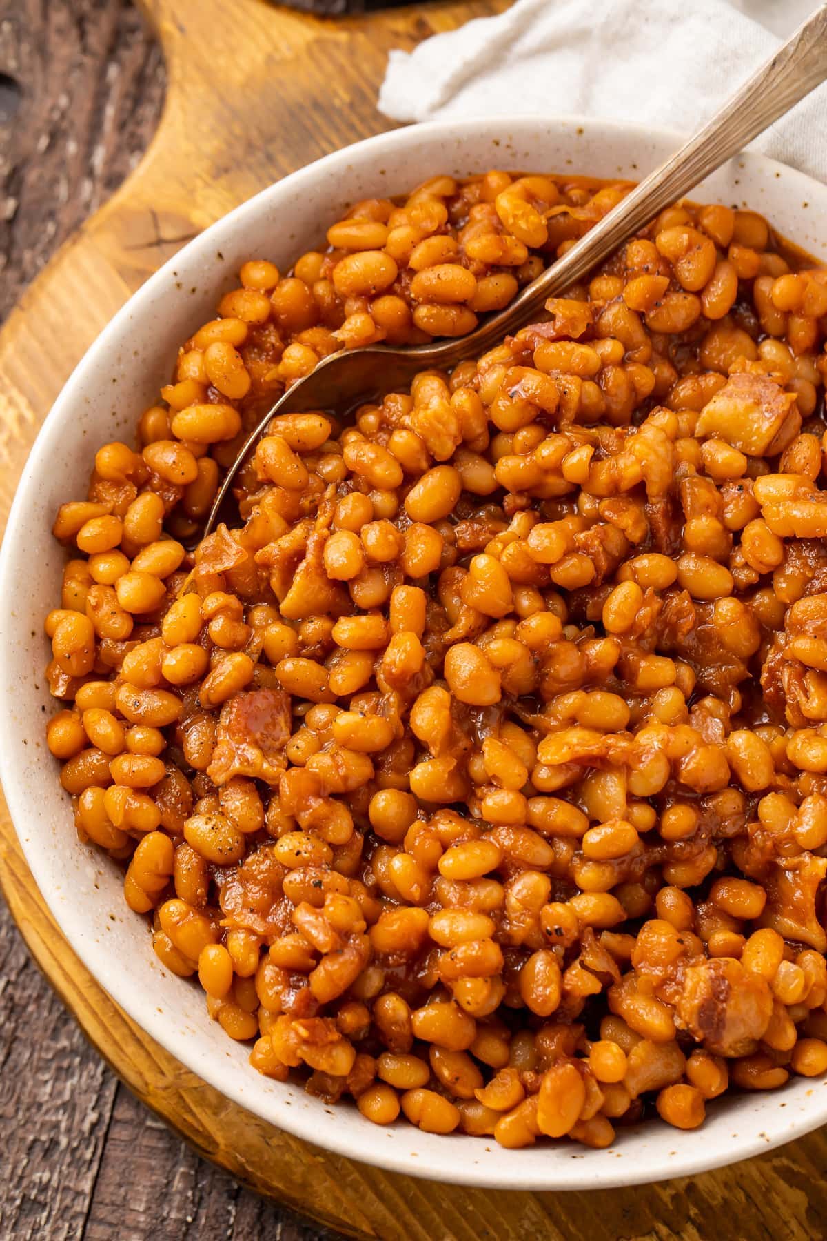 Overhead photo of Instant Pot baked beans in a white bowl on a wooden board