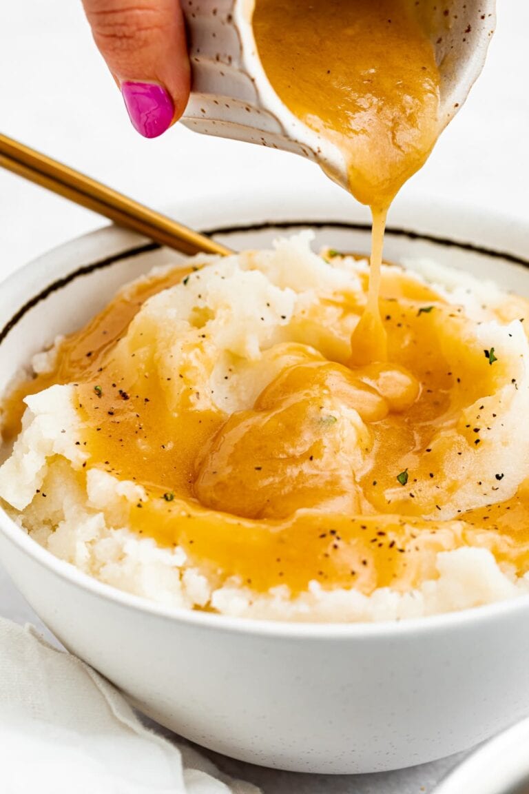 keto gravy being poured into a bowl of mashed potatoes