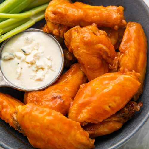 Air fryer chicken wings and celery on a platter with blue cheese dressing