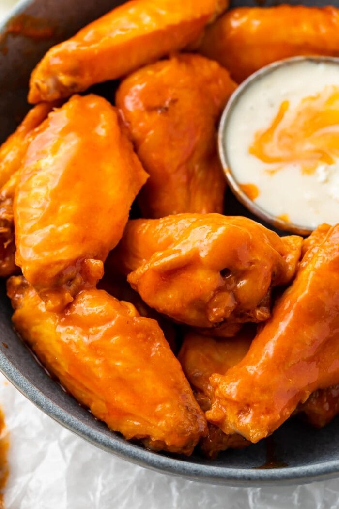 Air fryer chicken wings on a platter with sauce