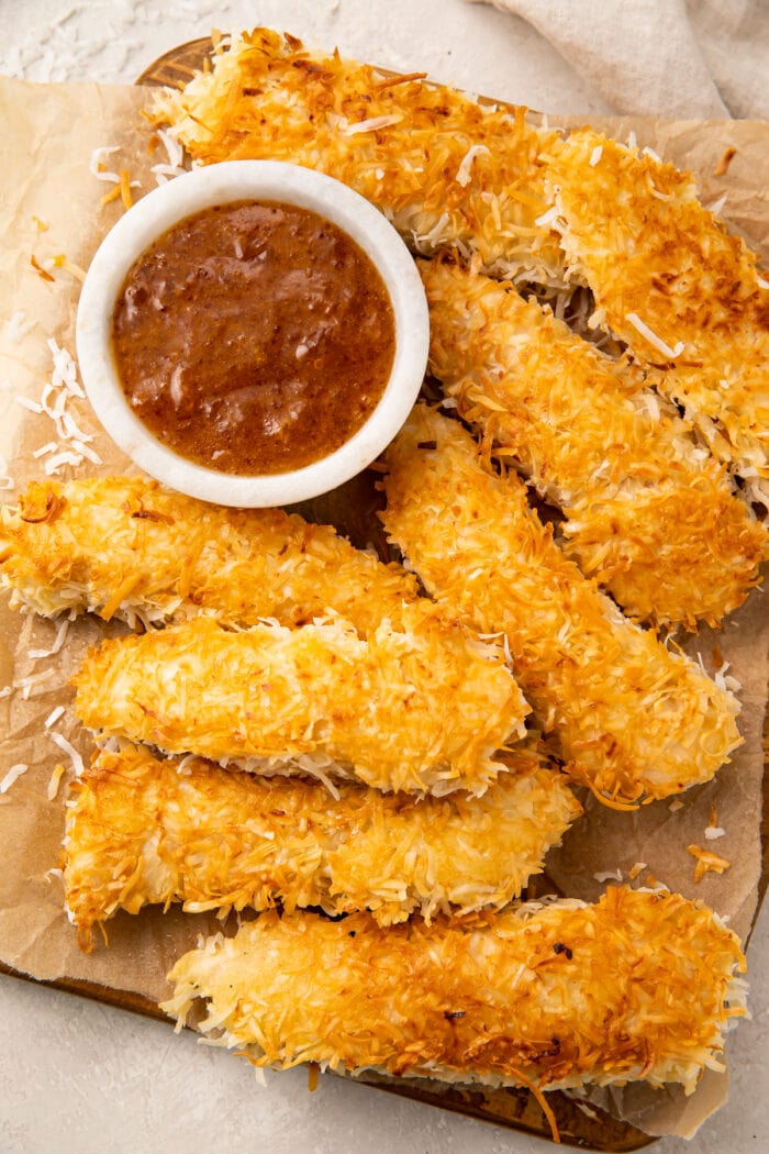 A platter of coconut chicken with a small bowl of orange-horseradish sauce