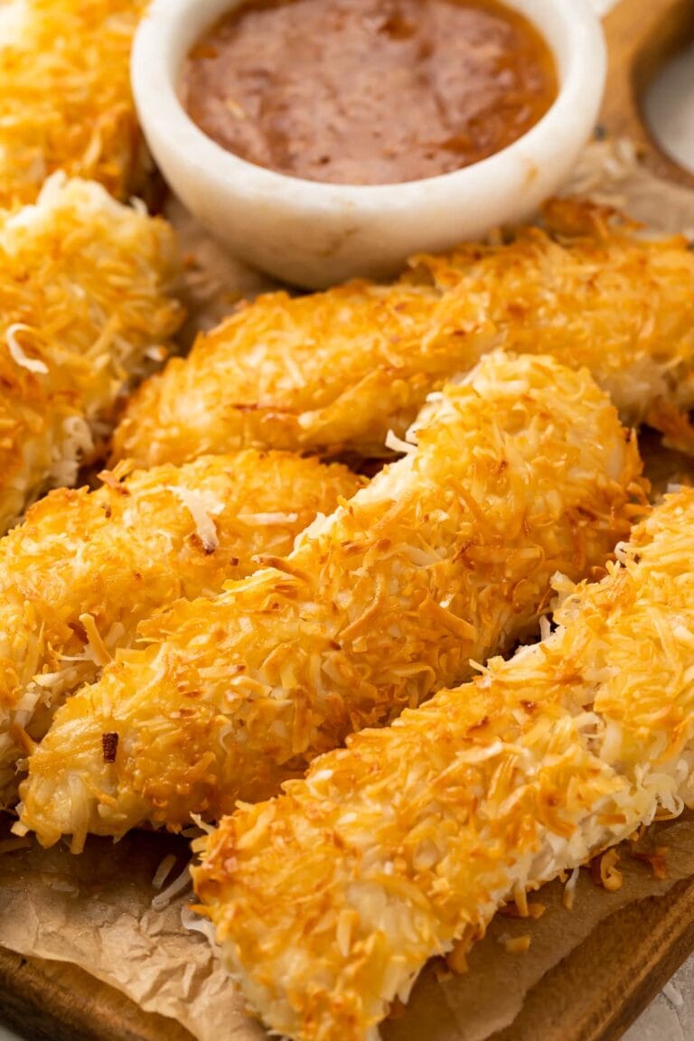 Crispy beer-battered coconut chicken on a plate next to orange-horseradish sauce