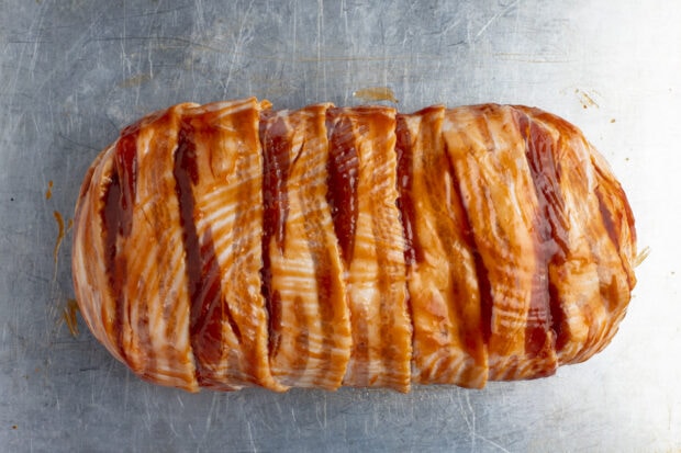 Bacon wrapped meatloaf on baking sheet