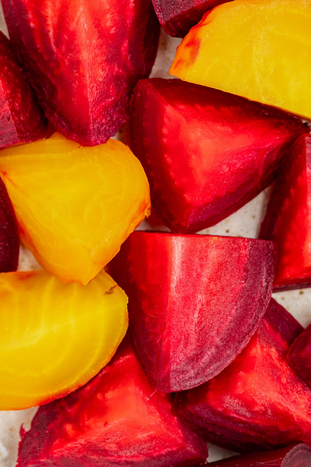 Close up of red and golden beets cut into large chunks.