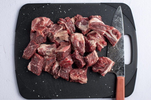 Cubed chuck roast on black cutting board