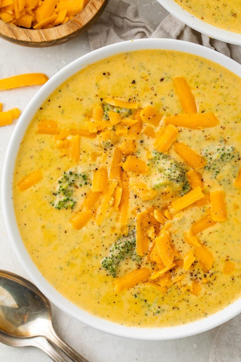 Overhead photo of keto broccoli cheese soup in a white bowl on a white table