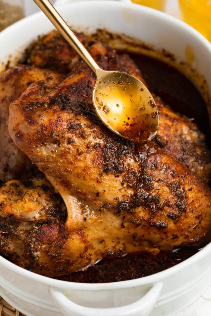 pan drippings being poured over baked turkey wings