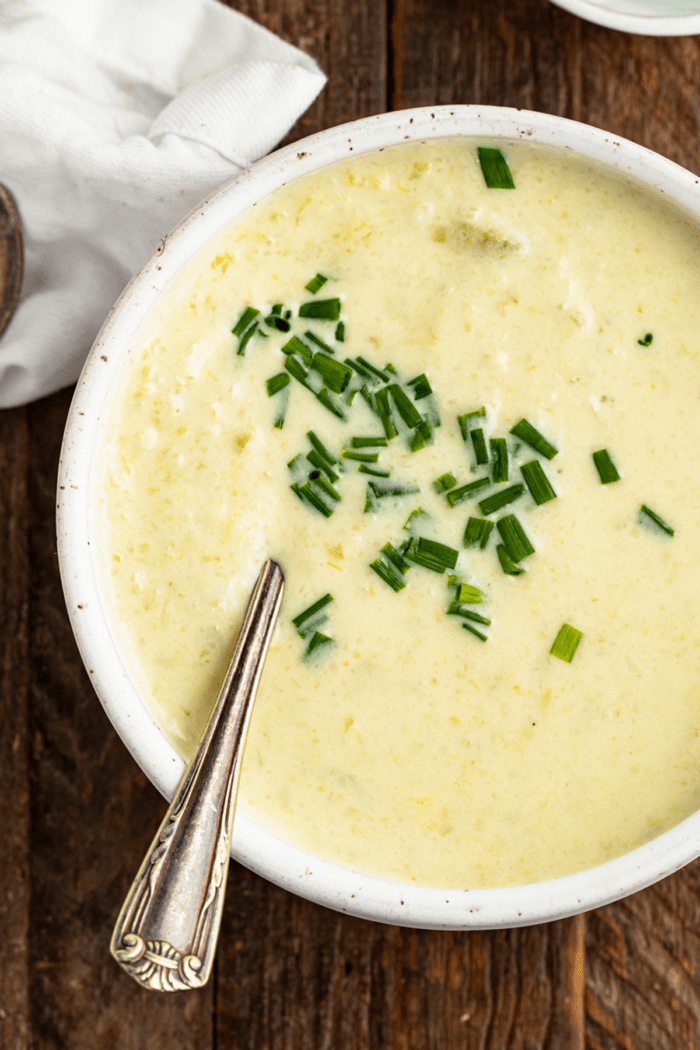 Overhead, close-up view of cream of celery soup in a bowl with a spoon