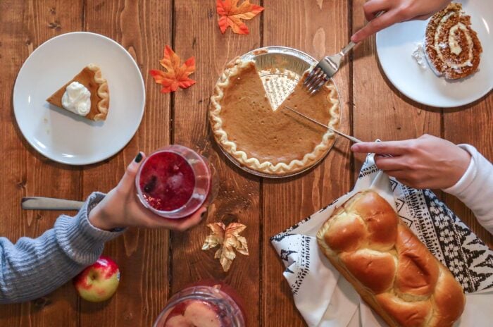 2 people sitting at a dinner table serving Thanksgiving dessert