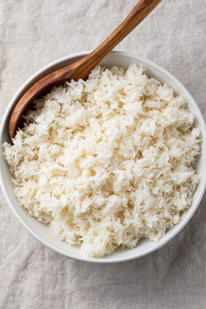 Overhead view of a large bowl of Instant Pot basmati rice with a wooden spoon on a table