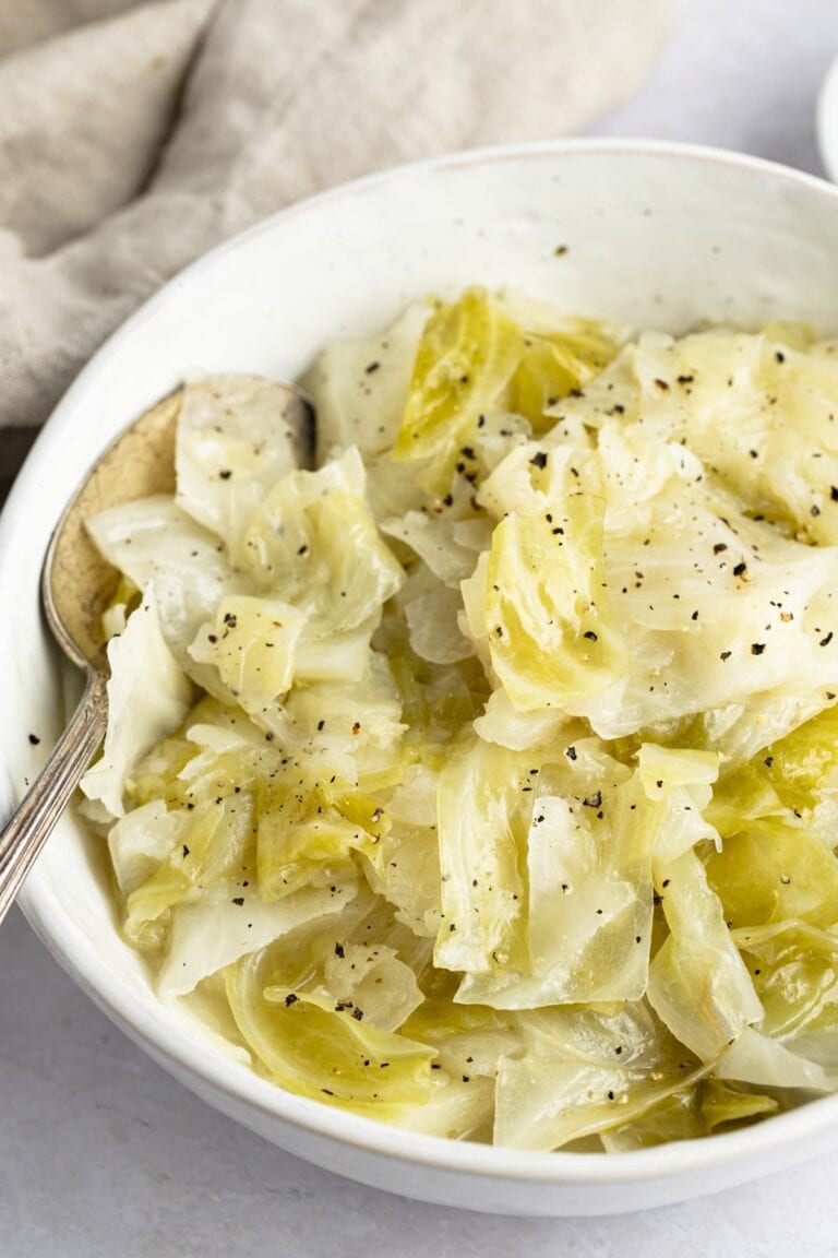 Instant Pot cabbage in a white bowl with a neutral napkin in the background