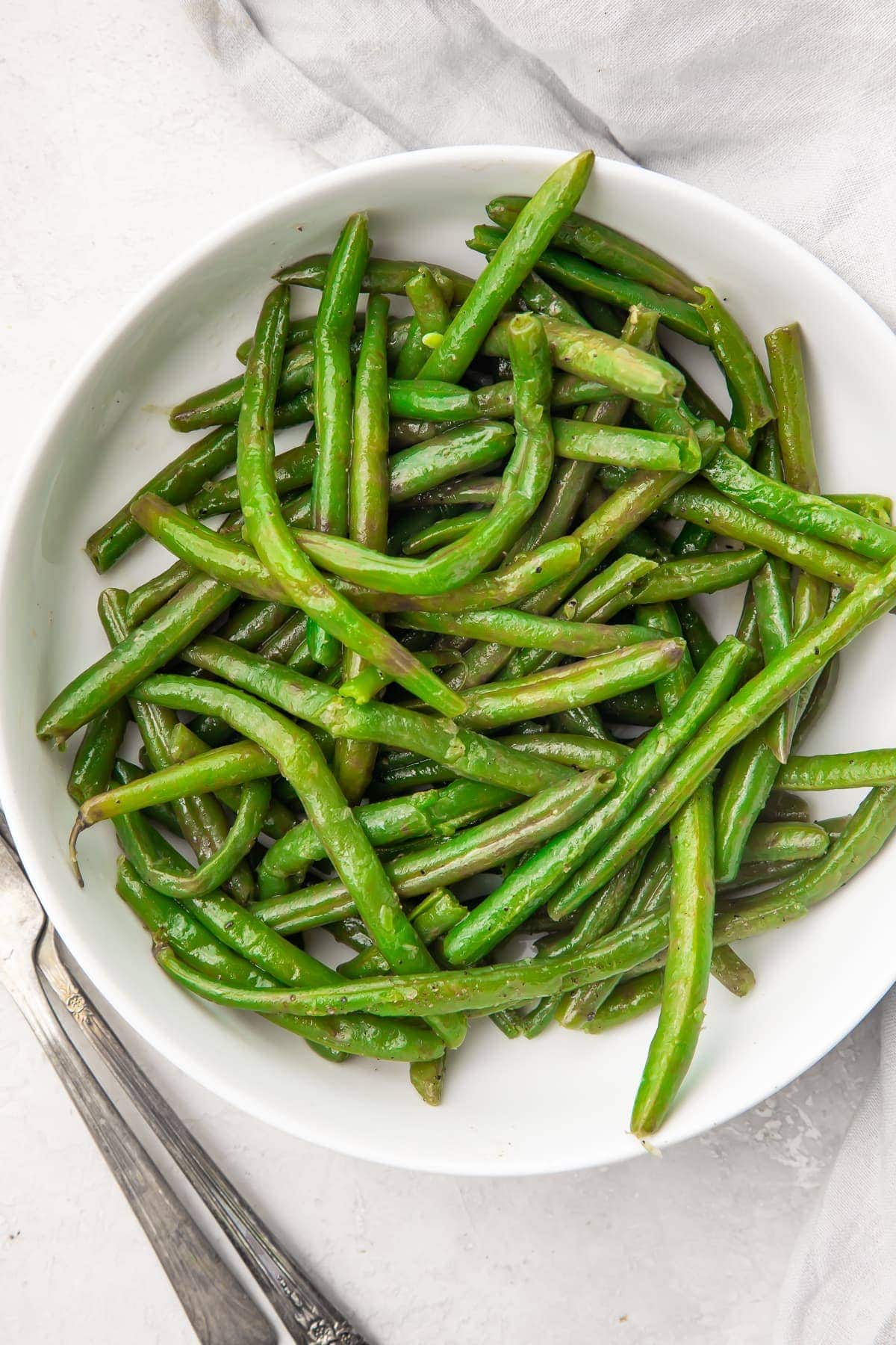 Overhead view of a large white bowl containing Instant Pot green beans