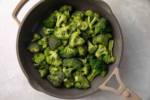 Sauteed broccoli in a large grey skillet