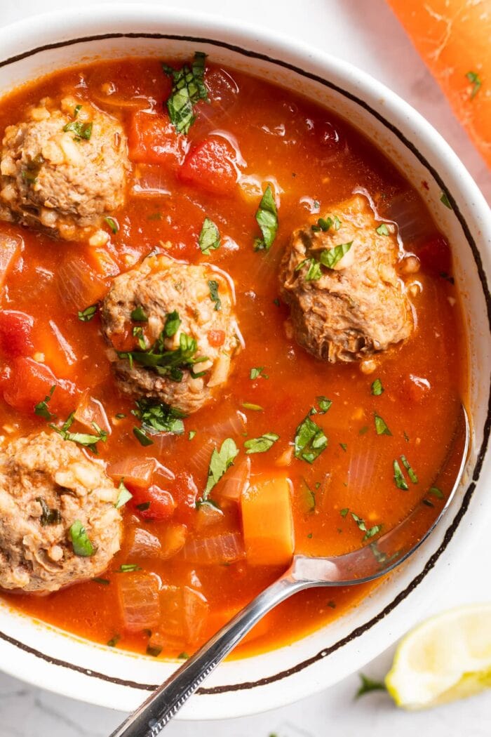 close up image of albondigas soup in a bowl with a spoon