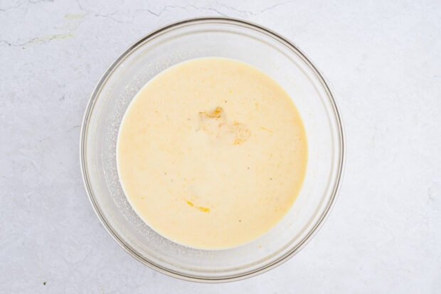 Wet ingredients for sweet potato pancakes in a large glass mixing bowl