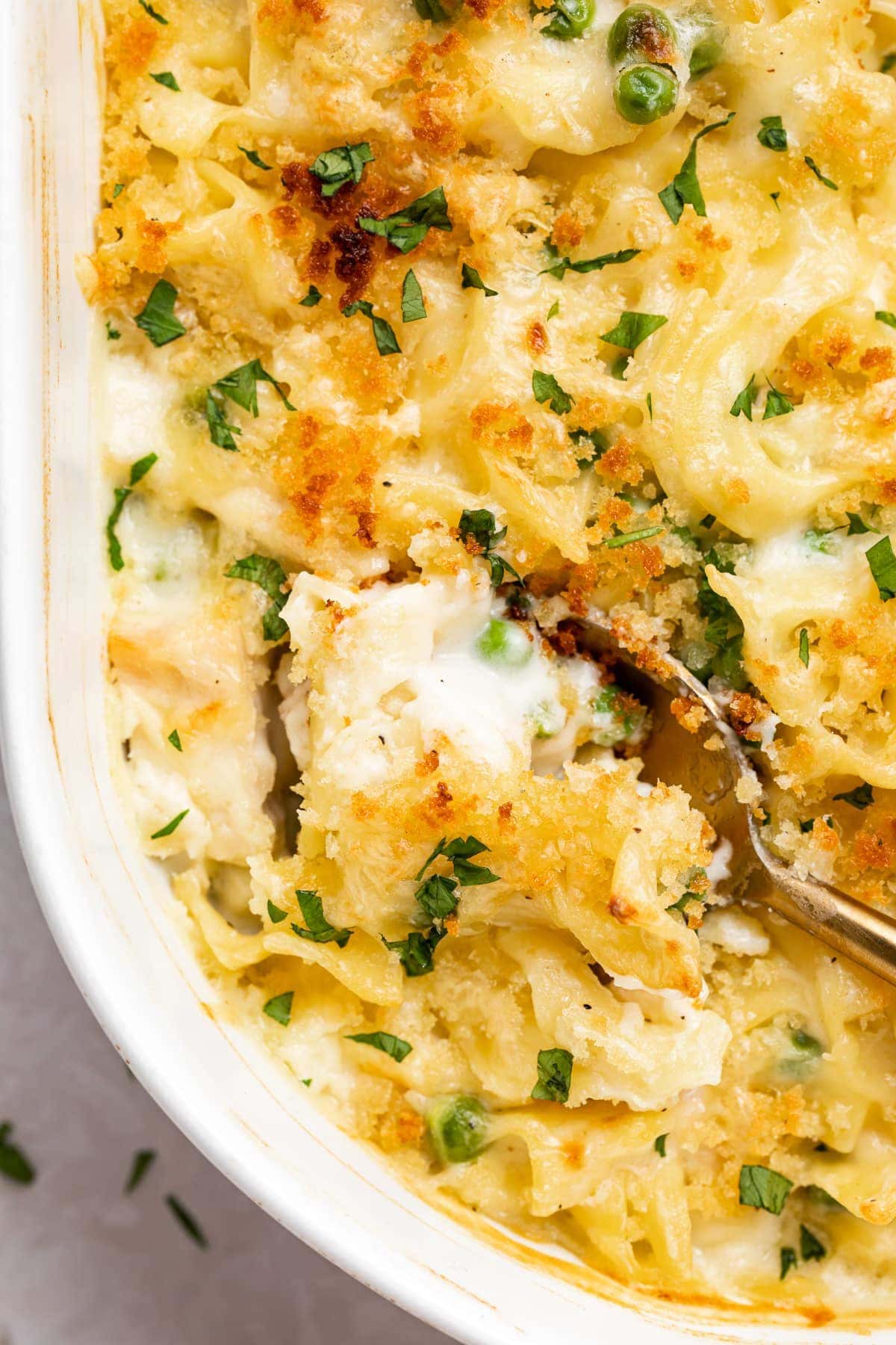 overhead image of turkey casserole being scooped out of a baking dish.