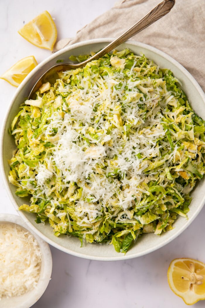 Overhead view of a bowl of shaved Brussels sprouts salad with lemon and parmesan