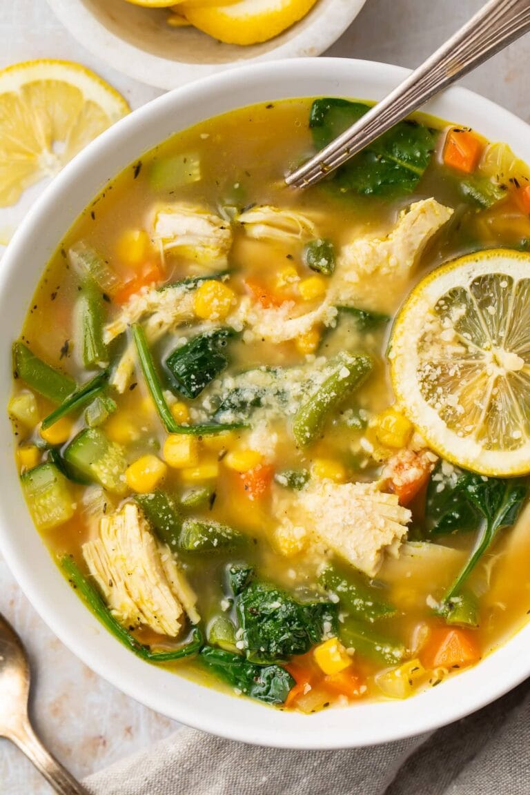 Overhead view of chicken vegetable soup in a white bowl