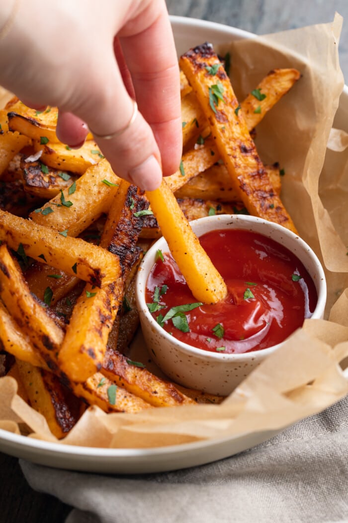 ritabaga fries being dipped in ketchup