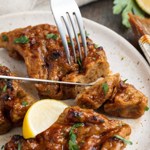 seitan grilled chicken being sliced on a plate