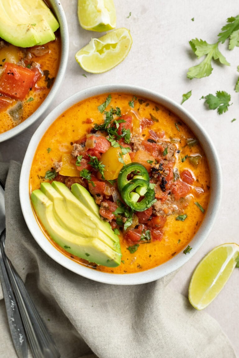 overhead image of whole30 creamy taco soup with sliced avocado and jalapenos on top