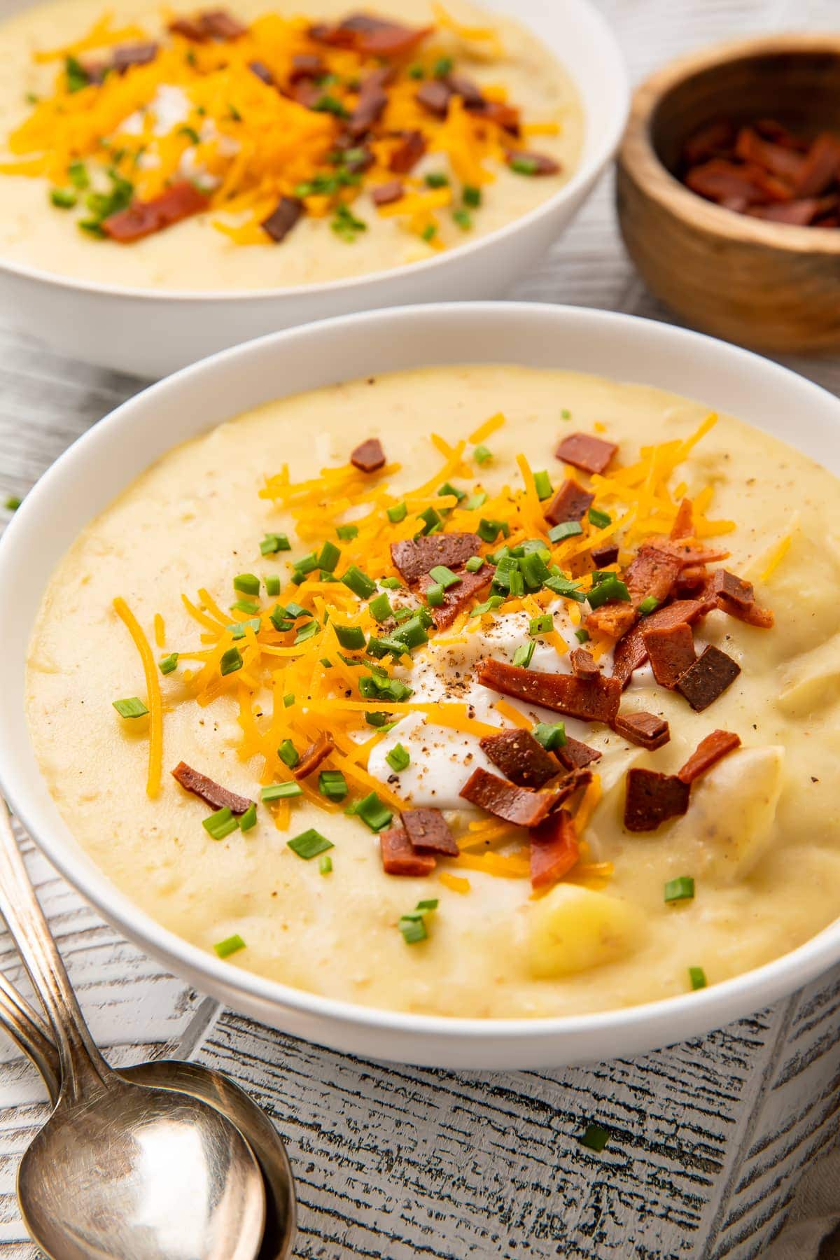 A side view of a bowl of vegan potato soup sitting on a table