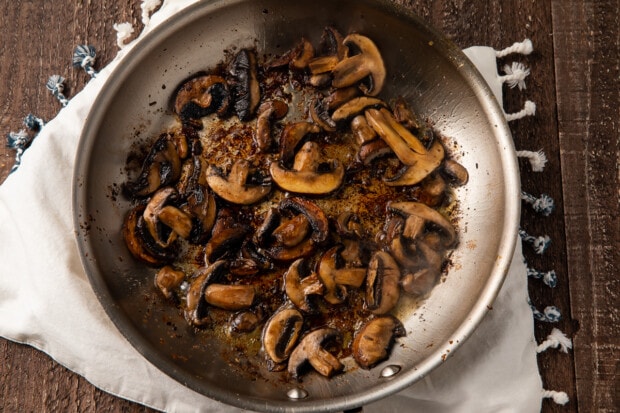 Sliced mushrooms in large silver skillet