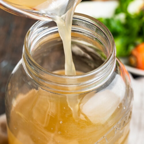 crockpot bone broth being poured into a jar