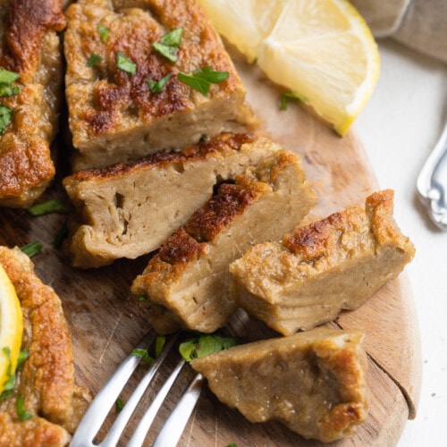 seitan chicken sliced on a cutting board with fresh parsley on top