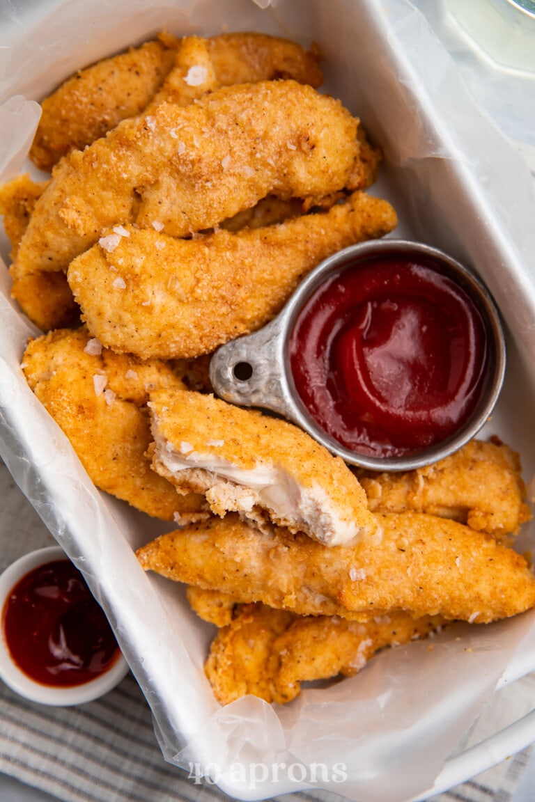 Whole30 chicken tenders in a baking dish with a dipping sauce