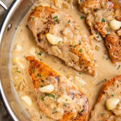 Overhead view of Whole30 creamy garlic chicken in a large silver skillet.