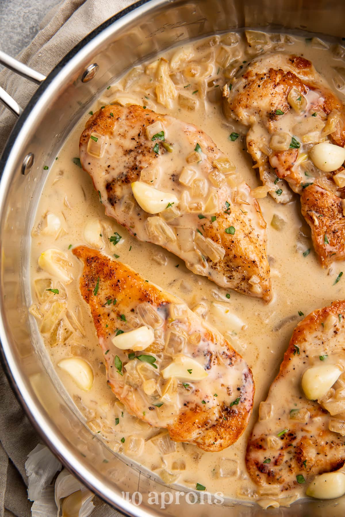 Overhead view of Whole30 creamy garlic chicken in a large silver skillet.