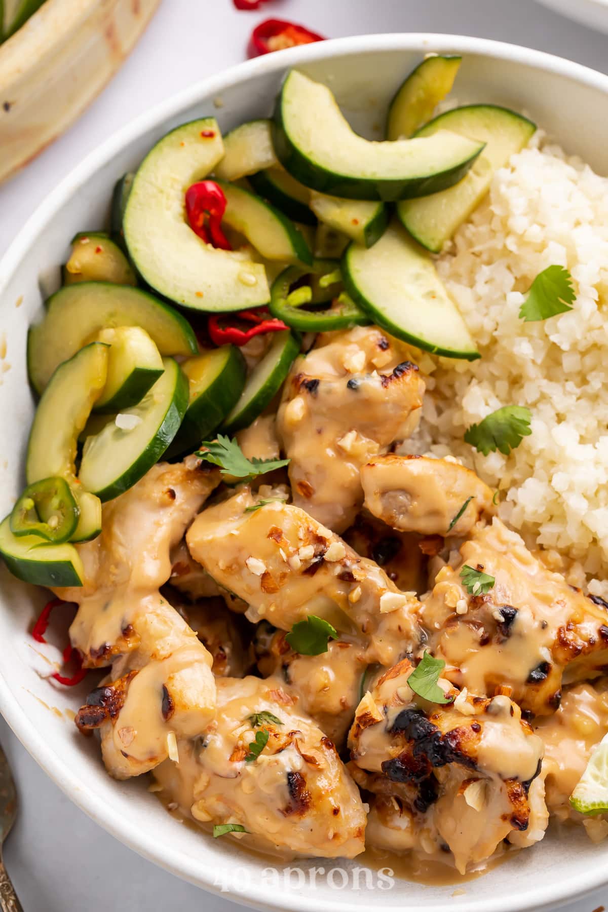 Overhead view of a Whole30 peanut chicken bowl with veggies